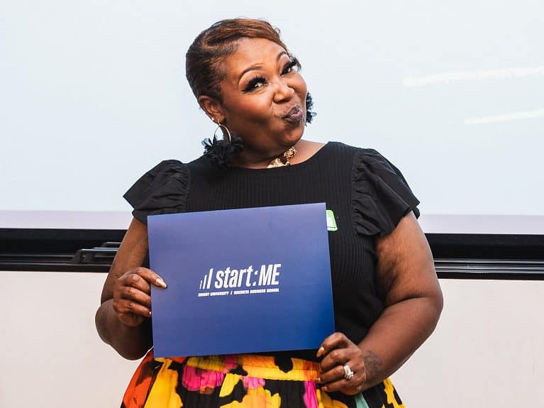 One of Goizueta's 2024 Start:ME program graduates poses with her certificate.